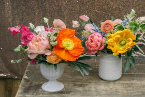 A cheerful mix of garden flowers are arranged in white vintage vases, ready for a Toronto dinner party.