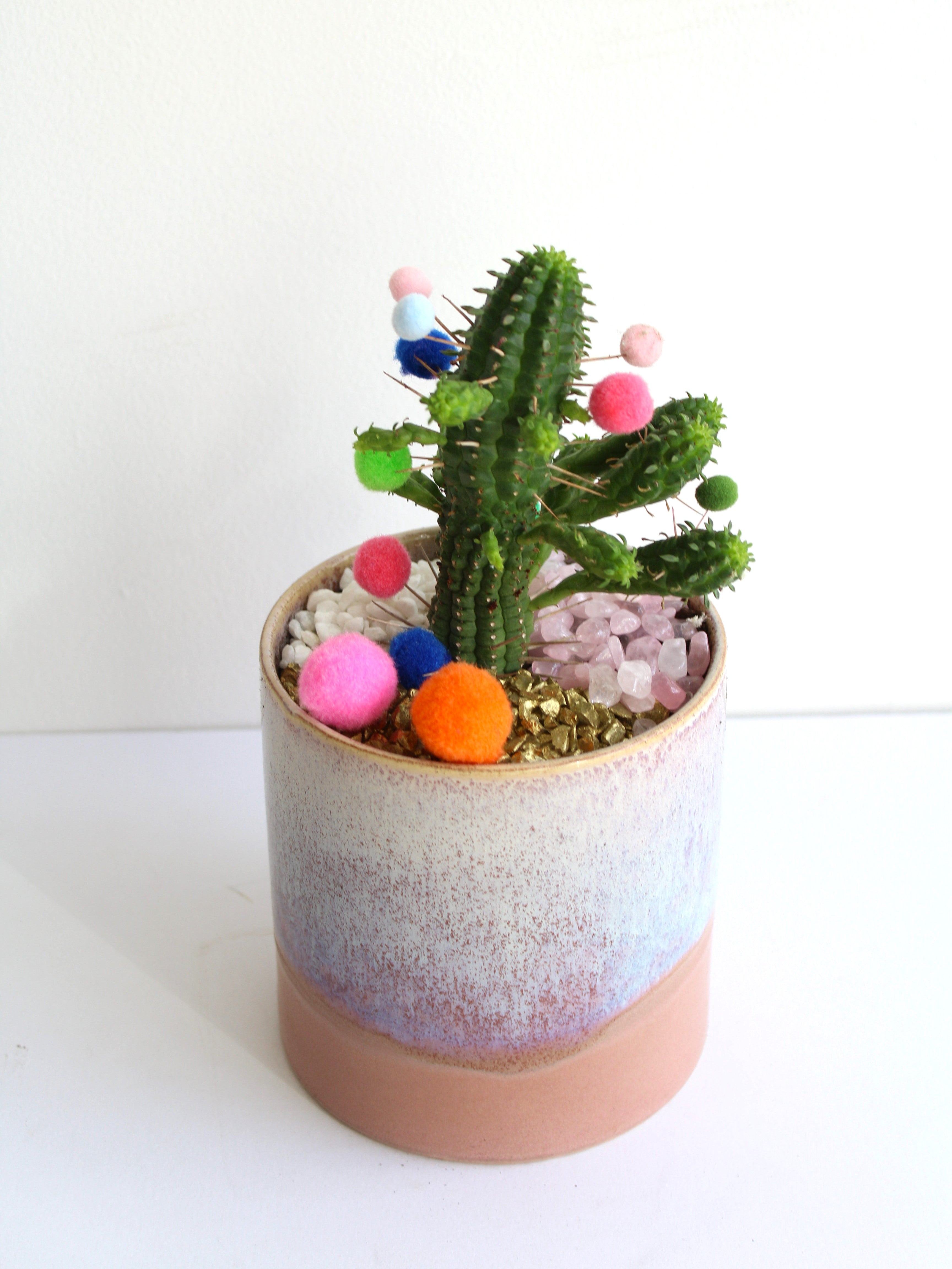 A potted cactus with festive pompoms.